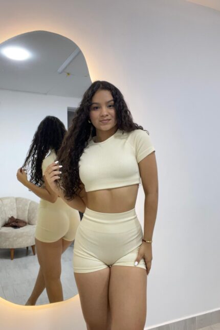 Este conjunto de dos piezas en tono beige claro combina estilo y comodidad a la perfección. Confeccionado en tela acanalada elástica, se adapta a tu figura realzando tus curvas de forma natural. Ideal para lucir fresca, cómoda y con un toque chic en casa o en salidas casuales. ¡Perfecto para destacar con un look minimalista y moderno!